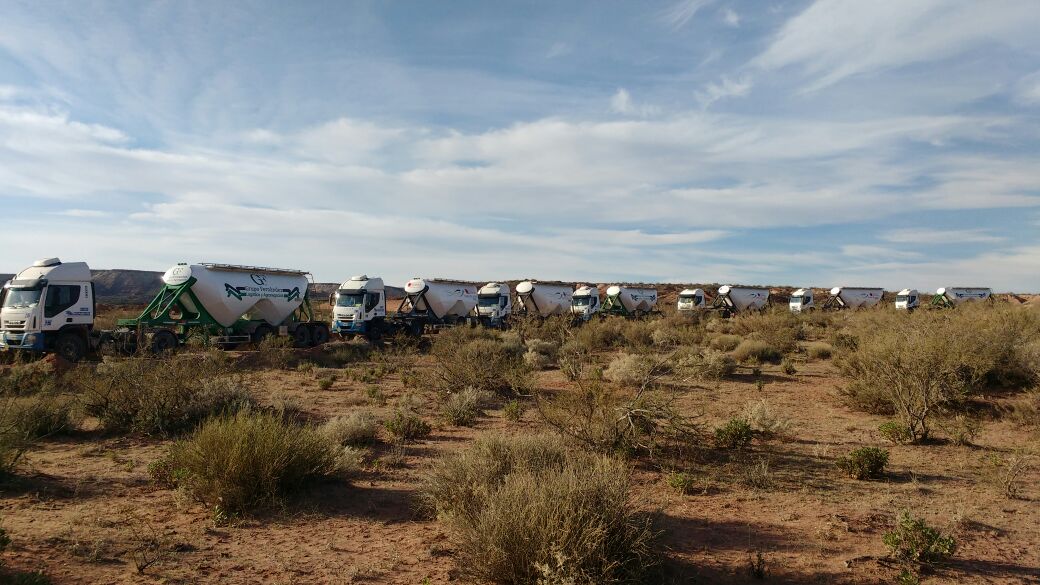 7 camiones en linea en calle de tierra
